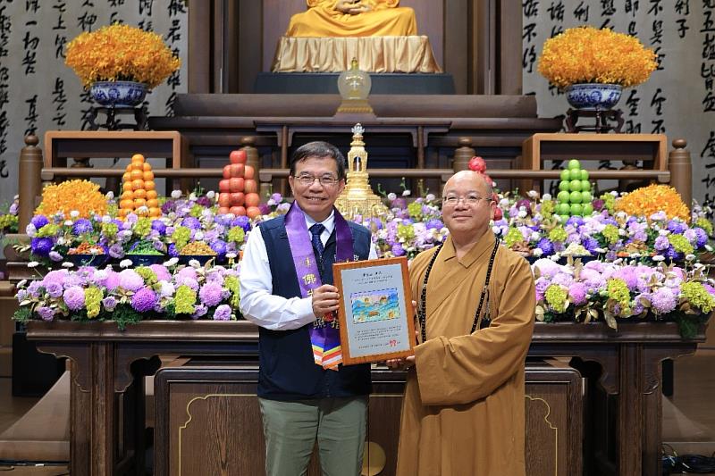 中華郵政公司董事長王國材（左）致贈郵票紀念框予佛光山，由住持心保和尚代表受領（右）。/中華郵政提供