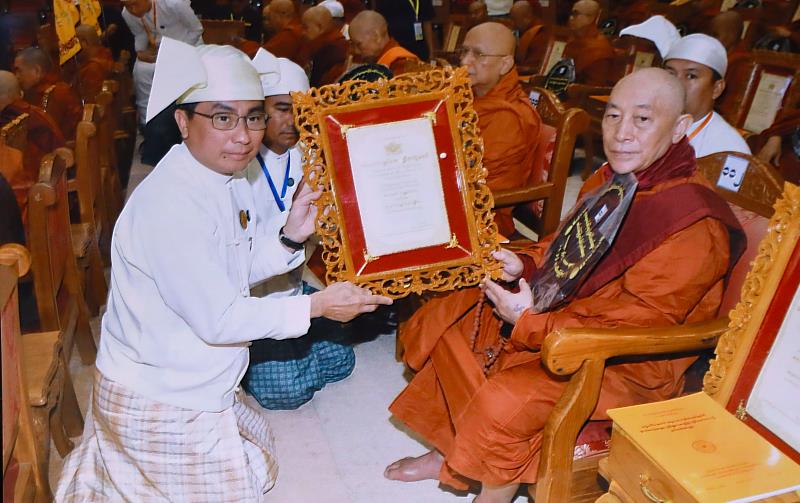 緬甸國家勞動部部長翁焦和（Aung Kyaw Hoe，左）代表頒贈「國家最高教育成就獎」獎狀予靈鷲山開山住持心道法師（右）。（圖由緬甸廣播電視台提供）