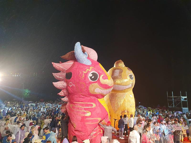 象徵「龍馬精神」的20呎巨型雙主燈在細雨中壯麗亮相。這對「龍馬神獸」主燈由一公一母組成,意涵家庭和諧與幸福圓滿;主燈身上承載著新北市長侯友宜題寫的「十分馬力,十分活力」賀詞,在百盞小天燈簇擁下,準備將眾人的心願帶往天際。