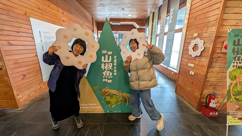 遊客手持特製的「山椒魚卵串」造型板拍照打卡，將形似甜甜圈的珍貴生態影像分享給更多人。