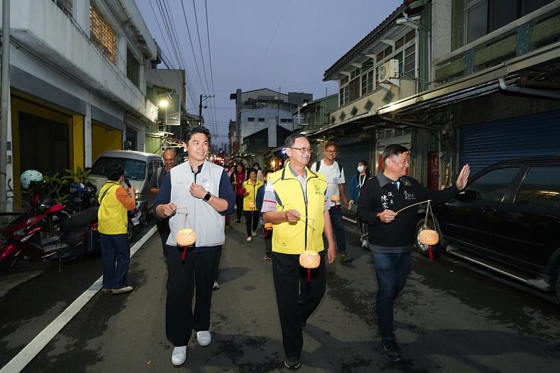 謝育哲局長提竹編燈籠沿巷弄漫步。