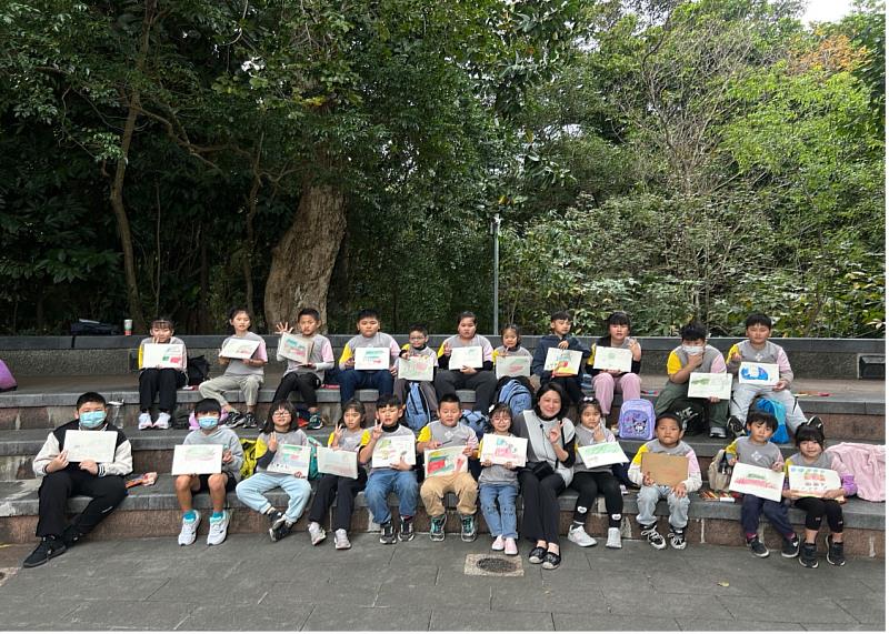 學童於植物園進行戶外寫生活動，在王貞懿老師（第1排右5）專業引導下完成創作。