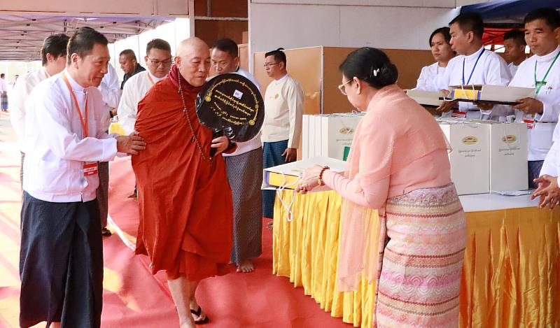 Grand Master Hsin Tao （second left） receives an offering from the wife of Senior General Min Aung Hlaing （right） after the ceremony. （Photo Courtesy of LJM）