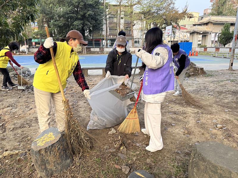 青年志工與義工夥伴分工合作清掃公園。