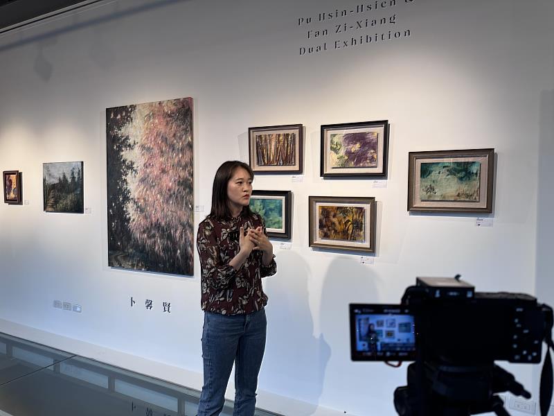 卜馨賢介紹作品《未命名之地》以層層疊合的筆觸描繪朦朧森林景觀，呈現記憶與感知交錯的風景意象。作品《鳳凰》以枯萎向日葵與火焰般色彩構成強烈畫面張力，象徵生命循環與重生的意象。