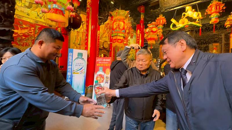 臺鹽公司董事長丁彥哲(右)與大甲鎮瀾宮董事長顏清標(中)發送台塩海洋鹼性離子水大甲媽祈福瓶,與現場香客結善緣,廣獲熱烈迴響。