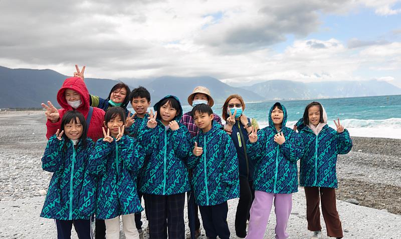 紅外套郭阿嬤雖腿腳不便，仍陪孩子們走到海邊尋寶。