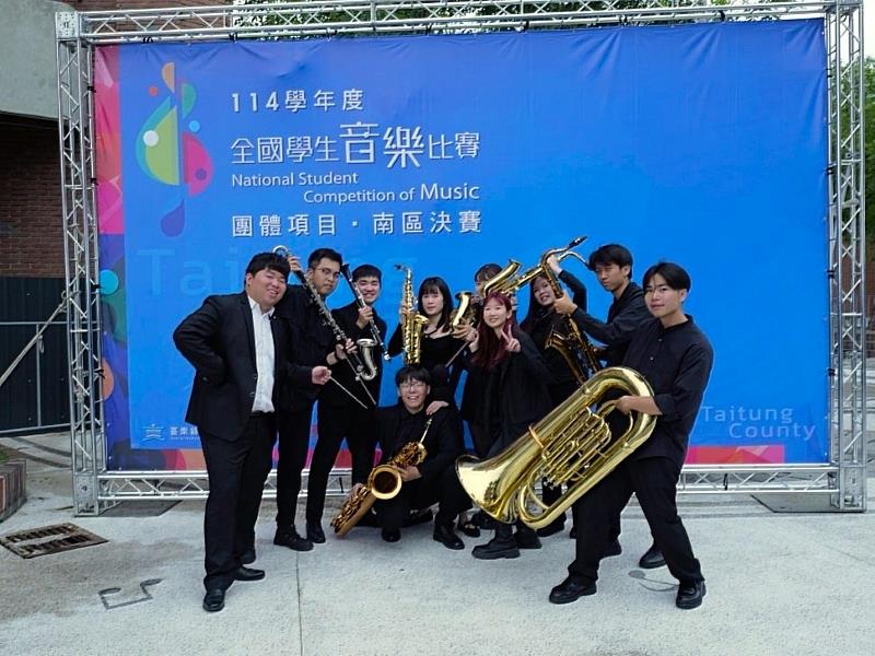南臺科大管樂社參加「全國學生音樂比賽南區決賽」勇奪優等佳績，圖為指導老師江浚瑋（左1）與演出團員於決賽會場主視覺前開心合影留念。