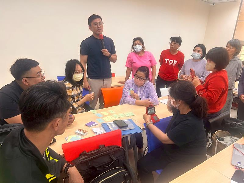 鍾孟修老師（持麥克風者）強調教具簡化與活動深化的設計理念。