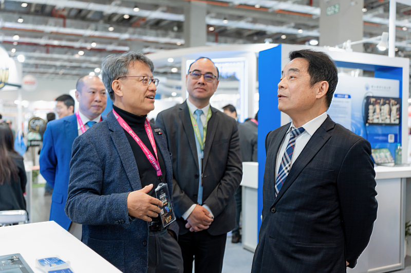 Deputy Minister Sheng-Yuan Wu of the Ministry of Transportation and Communications listens as NYCU Vice President for OIAC Hank Huang presents key exhibition highlights.