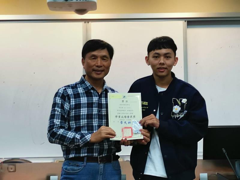 林文暉老師（左）頒發學業成績優異獎予三年級李忠森。