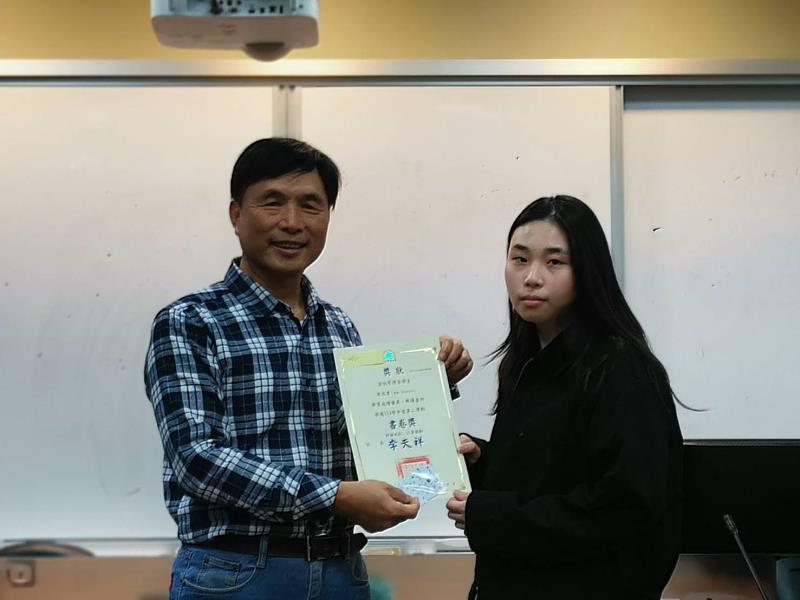 資管系林文暉老師(左)頒發書卷獎予三年級李水香。