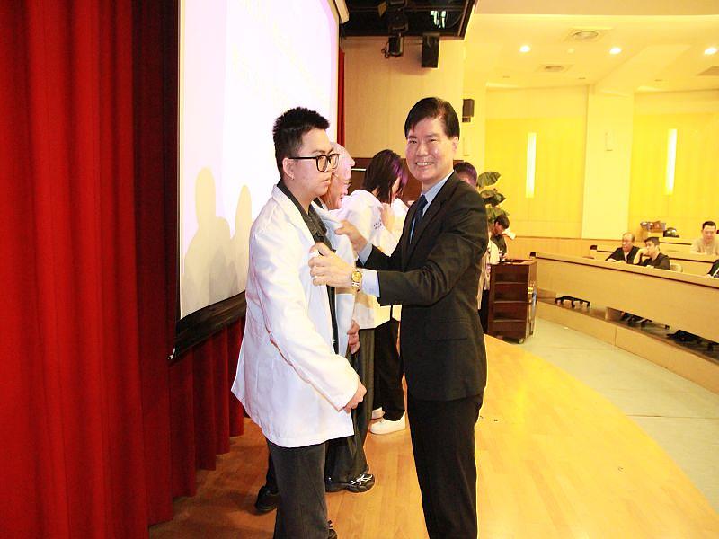 小林眼鏡公司張騰達總經理為元培視光系學生授袍，期勉學生累積實務經驗。