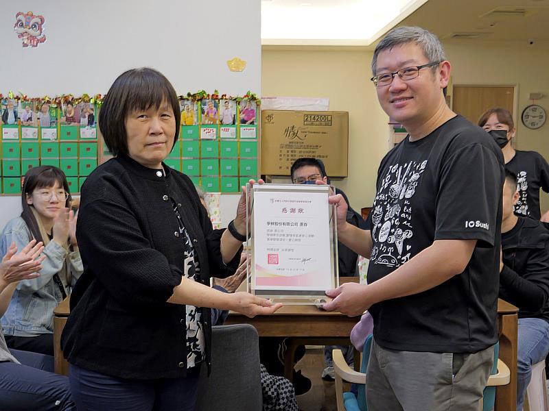 門諾基金會公共事務處李麗雲主任(左)致贈感謝狀給爭鮮,由鄭棟文區經理受贈。