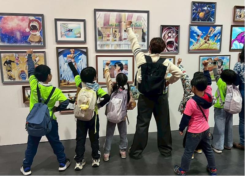 新北市插角國小師生於展區模仿角色動作合影,熱愛《航海王》的教師與學童一同投入其中。