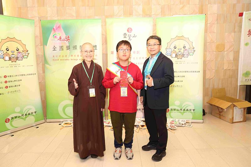 台南市宅港國小的周君憲（中），與台南分院監院晟芝法師（左）、校長林維智合影。（圖由靈鷲山佛教教團提供）