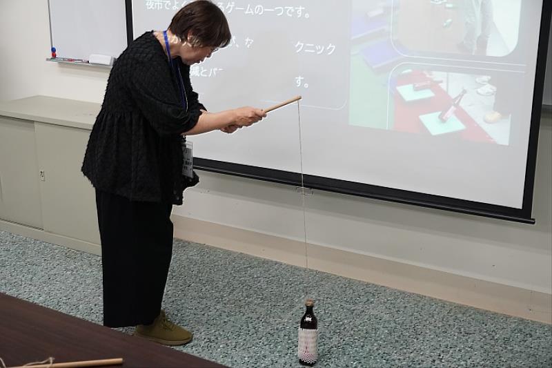 宮城教育大學高橋亞紀子老師親身體驗臺灣傳統遊戲「釣酒瓶」，在輕鬆愉快的互動中感受中華大學學生用心安排的在地文化魅力。