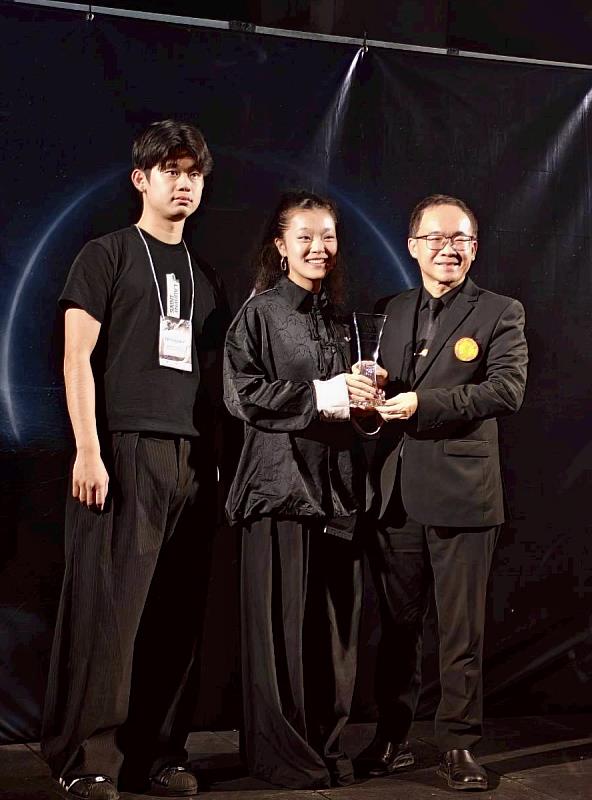 作品《BETONHAUT》榮獲2026年第十五屆泰國曼谷FVT服裝設計大賽 「最佳精工製作獎」,由左起:崔友亮、林芷杏代表領獎。