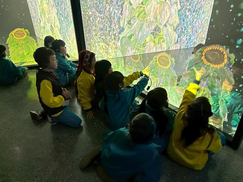 在以克林姆花園為靈感的沉浸式展區中，孩子們伸手互動、專注觀察，感受藝術的純粹與美好。（圖片為來自新竹縣的五峰國小）