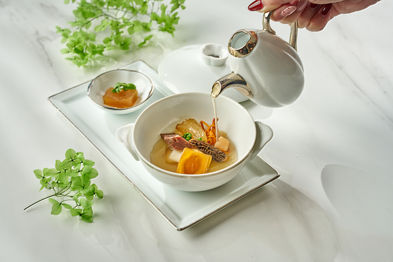 「鮑潤牛湯琥珀凍」嚴選牛大骨、牛筋與和牛臉頰，佐以10餘種時蔬慢火熬煮10小時，將濃醇湯底注入鮑魚並冷凝成天然膠質凍體。「一湯二吃」先品嚐凝凍後的鹹鮮風味，再沖入熱湯回歸濃厚湯韻。（圖/六福旅遊集團提供）