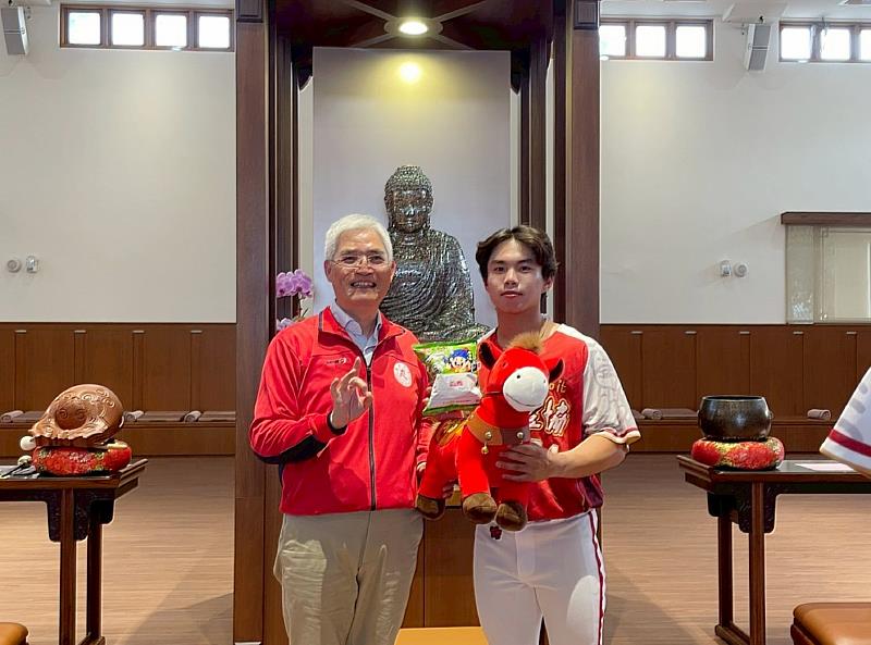 南華大學甲組棒球隊授旗出征，高俊雄校長（左）特別致贈象徵「馬到成功」的吉祥物。