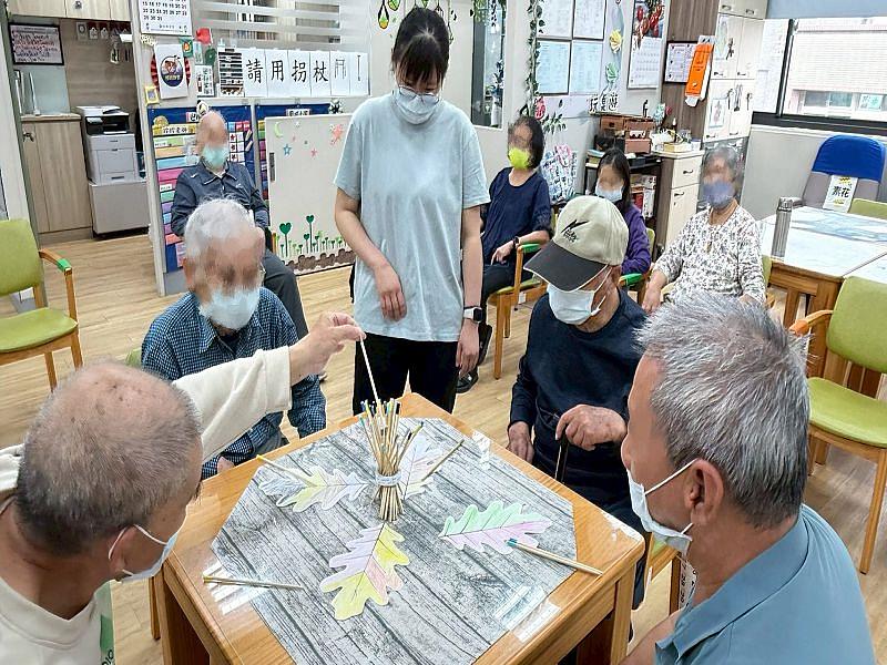 高齡健康照護系陳芷樺同學（中）在長照機構細心的與長者互動。