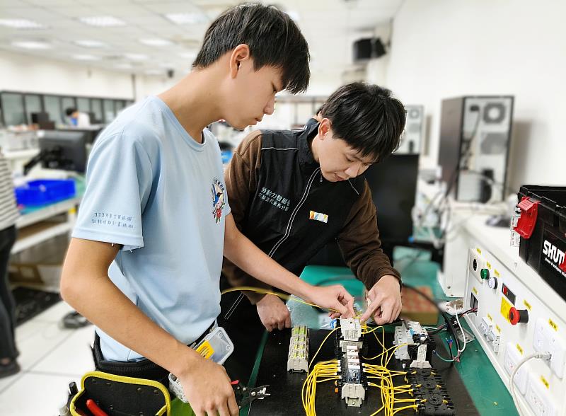 北分署與新北市立正德國中共同培訓選手李一鑫（左），接受北分署訓練師李亞軒（右）指導，獲得青少年組「工業控制」職類金牌。