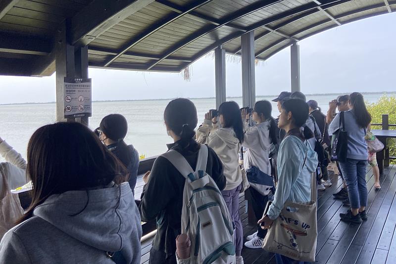 南大師生於黑面琵鷺保護區賞鳥亭觀察水鳥活動，透過望遠鏡體驗濕地生態，認識台江環境特色。