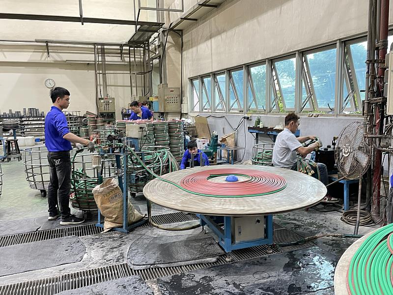 工作人員操作大型自動轉盤設備，該設備的建置，高度仰賴機械系教授張銘崑行政長師生團隊的產學合作。