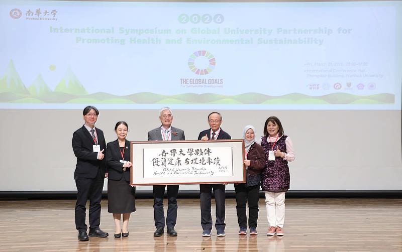 南華大學舉辦國際研討會，高俊雄校長（左3）以「世界大學夥伴推動優質健康與環境永續」墨寶致贈給大會。
