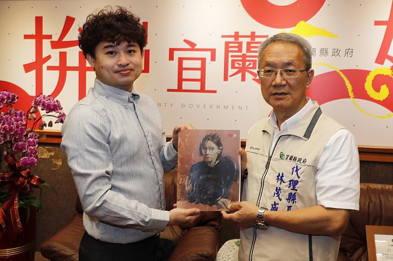 攝影家游家豪（左）致贈攝影大賽年鑑給代理縣長林茂盛（右）。