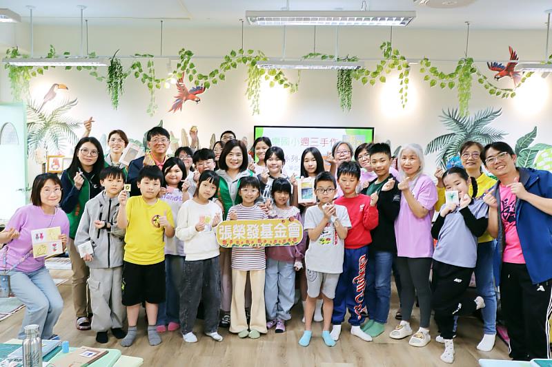 張榮發基金會執行長鍾德美（中著綠背心）與基隆市長樂國小創課社團師生持刺繡作品合影。