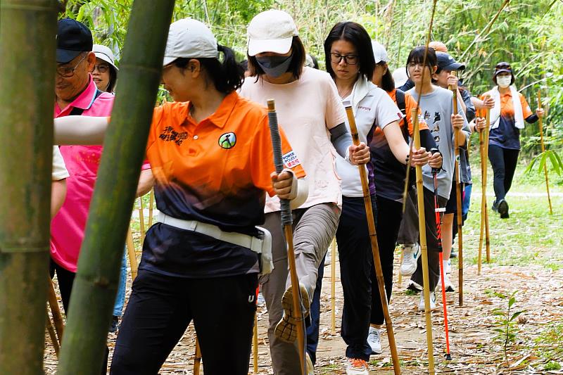 民眾在專業教練帶領下進行持杖健走，透過規律運動強化肌力與平衡，打造防老抗衰的健康生活方式。