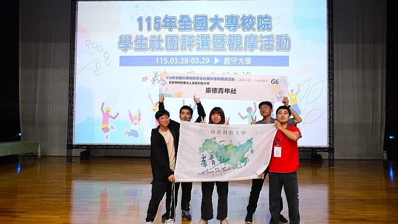 南臺科大『崇德青年社』於115年全國大專校院學生社團評選榮獲「佳作」。社員手持『崇德青年社』背板在舞台上開心合影。