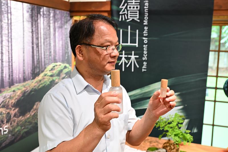 嘉義分署分署長李定忠手持新品精油及香氛，說明林業剩餘資材經過循環利用，以新面貌進入生活。