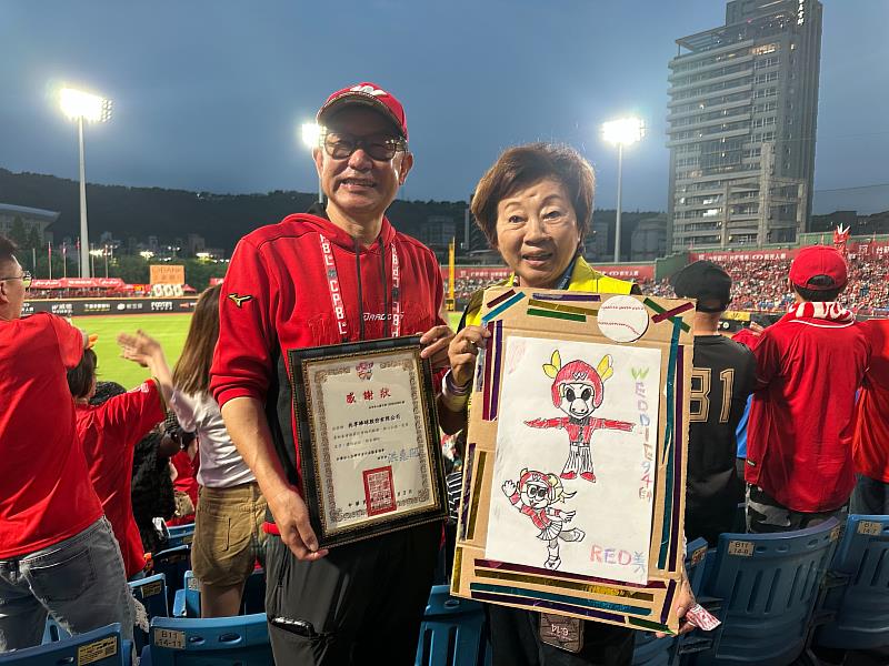 味全龍球團董事長簡倍祥接受身心障礙青年親手繪製的吉祥物威弟與芮美畫像。（頂新和德文教基金會提供）