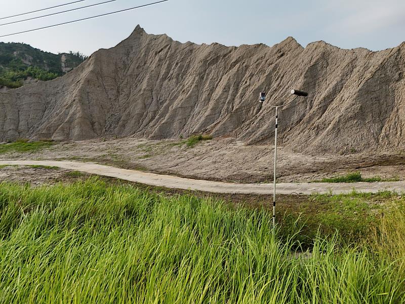 為了監測草鴞活動設置的棲架，棲架下方即是濃密的純白茅草生地，與後方的惡地地形相互輝映。