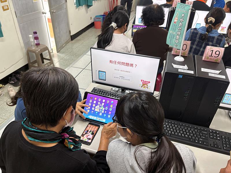 孩童們教導長輩使用平板。