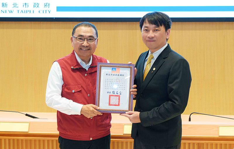 永慶房屋積極投入社區防災，連5年受新北市政府消防局肯定，由新北市市長侯友宜（左）親自頒獎，永慶房屋楊哲彥協理（右）代表受獎。