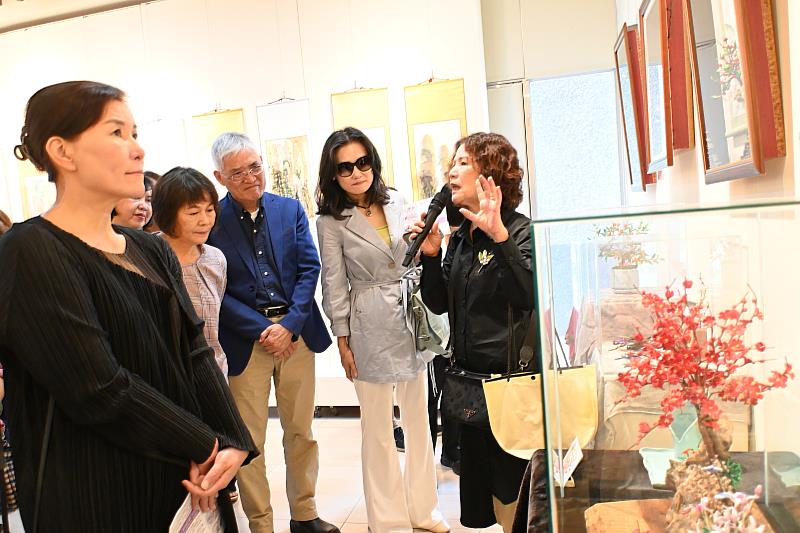 南華大學終身學院舉辦樂齡成果展，洪銀霜學員為貴賓介紹精美的纏花創作。
