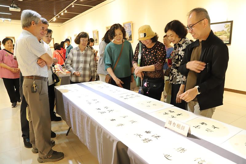 南華大學終身學院舉辦樂齡成果展,學員們互相欣賞臨摹的書法。右1為呂嘉民老師。