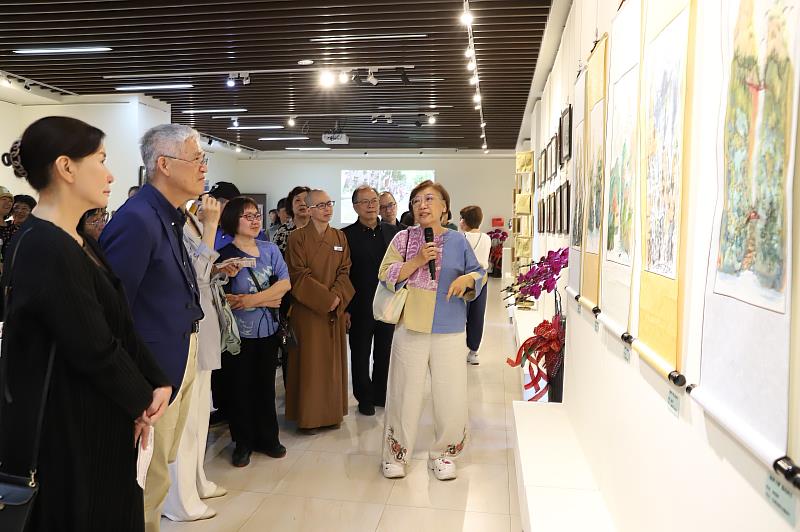 南華大學終身學院舉辦樂齡成果展,水墨畫賞析創作課程諶麗美老師為貴賓介紹學員的作品。
