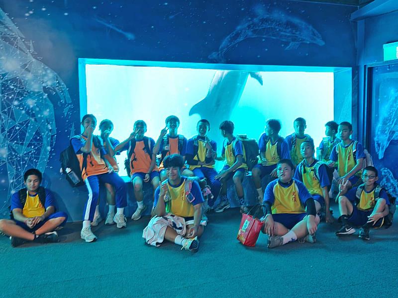 花蓮縣光復國中學生觀賞表演前，在水族館前與鯨豚合影。