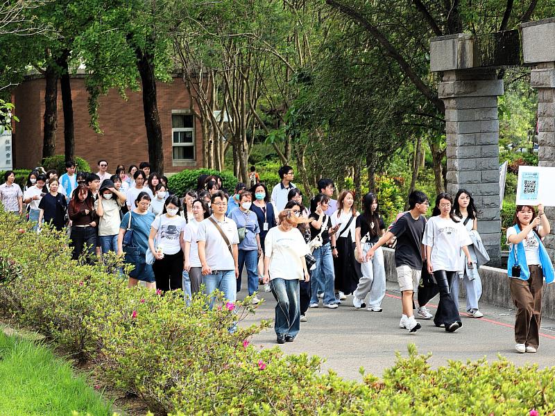 在校生舉牌引導，親切帶領考生熟悉校園環境。