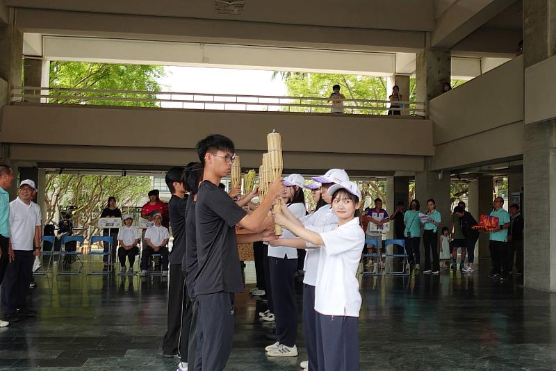 中央大學聖火隊與高科大代表於行政大樓進行聖火交接儀式，象徵全大運精神延續與傳承。