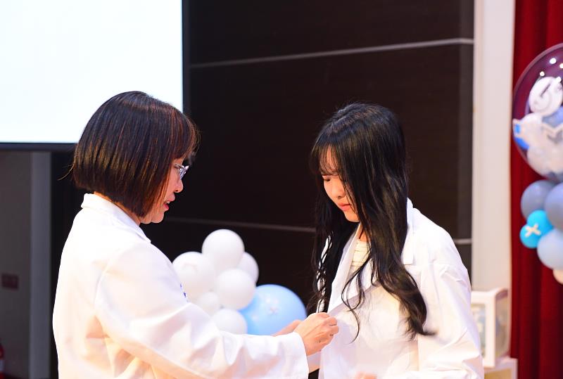 醫檢系陳碧蓮主任幫實習生授袍。