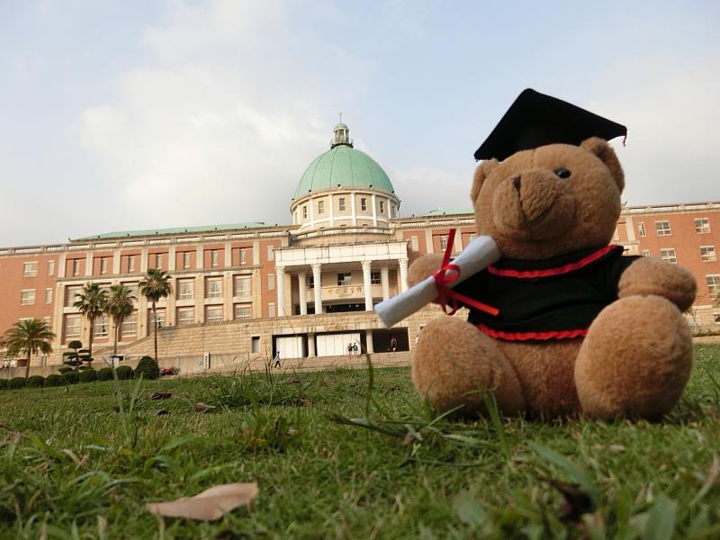 穿著學士服的可愛小熊與亞大校園美景同框，為美好的大學青春歲月溫馨定格。