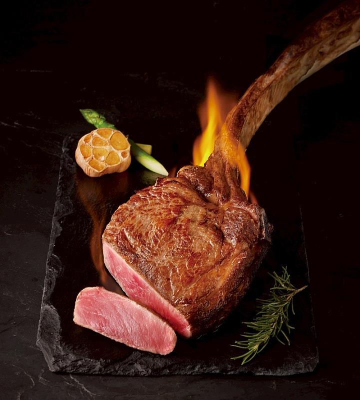 「澳洲穀飼厚切戰斧牛排」主餐：外酥內嫩，重達36oz的氣勢份量，歷經高溫炙烤與烈焰儀式展演，是全家人共度「精心時刻」的最佳主角。