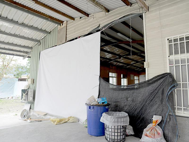 花蓮光復鄉大同村受災的黃姓住戶修繕前，以帆布遮擋破損牆面防風避雨。