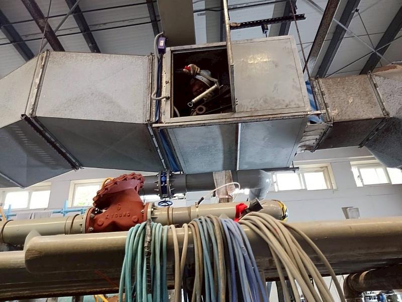 人員於狹小抽送風機進行打油保養，維護設備順暢運轉。